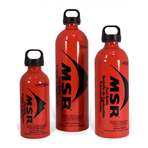 Se muestran en posición vertical tres botellas de combustible MSR rojas, incluida una opción de 887 ml. Con tapas y etiquetas negras con el logotipo de la marca e información de seguridad, estas botellas combinan perfectamente con una estufa Cocinilla o MSR WhisperLite Universal para un almacenamiento de combustible al aire libre confiable.
