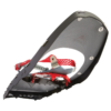 Un primer plano de las Raquetas de Nieve MSR Lightning Ascent 25 muestra una raqueta de nieve negra y roja con clavos de metal, con un marco resistente y correas ajustables para tracción y estabilidad en terrenos nevados.