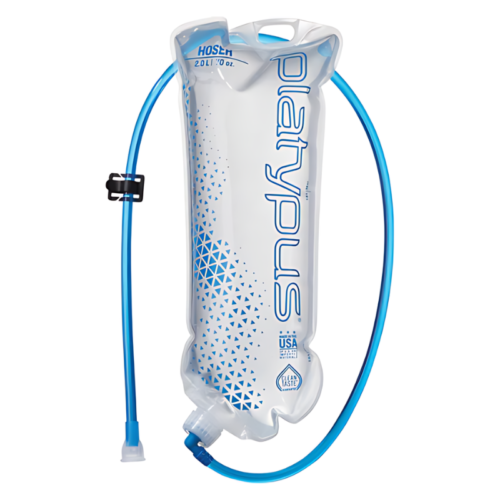 Bolsa de hidratación blanca con motivos geométricos azules, con la marca "Platypus" en azul. Tiene una capacidad de 2,0 litros y un tubo para beber azul con un clip negro y una válvula de mordida. La bolsa tiene la leyenda "Made in USA".