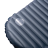 Un primer plano de un colchón inflable gris, similar al Tensores Reflectantes MSR Reflective Utility Cord (copia), muestra una reparación con un parche circular cerca del centro. La textura acanalada se destaca claramente contra el fondo blanco liso.