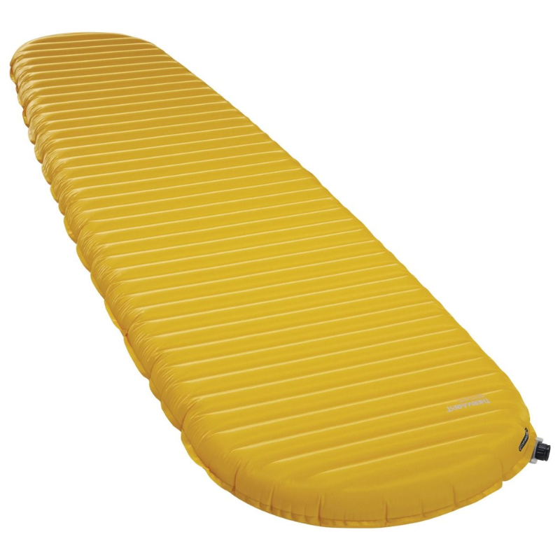 La colchoneta inflable Therm-a-Rest NeoAir XLite NXT es de color amarillo, con crestas horizontales y forma cónica, ideal para acampar al aire libre. Tiene una pequeña válvula en un extremo para inflarla y desinflarla fácilmente.