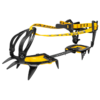 Un par de crampones de alpinismo Grivel G10 negros y amarillos con clavos de metal y correas ajustables. El diseño combina componentes de plástico y metal, lo que garantiza un ajuste seguro a las botas en condiciones de hielo o nieve.