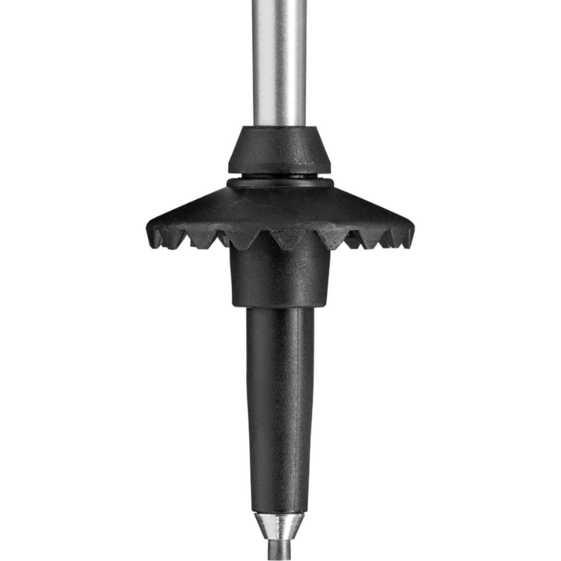 Primer plano de la punta de un bastón de trekking Leki Eagle, que muestra una punta de metal con una canasta protectora negra. La canasta con bordes dentados está diseñada para evitar que el bastón se hunda en terrenos blandos.