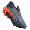 La zapatilla de montaña La Sportiva Akyra II GTX (copia) azul y naranja se muestra desde un ángulo bajo, resaltando una suela resistente con tacos naranjas llamativos para mayor tracción. El llamativo logotipo naranja de La Sportiva adorna de manera prominente el costado.