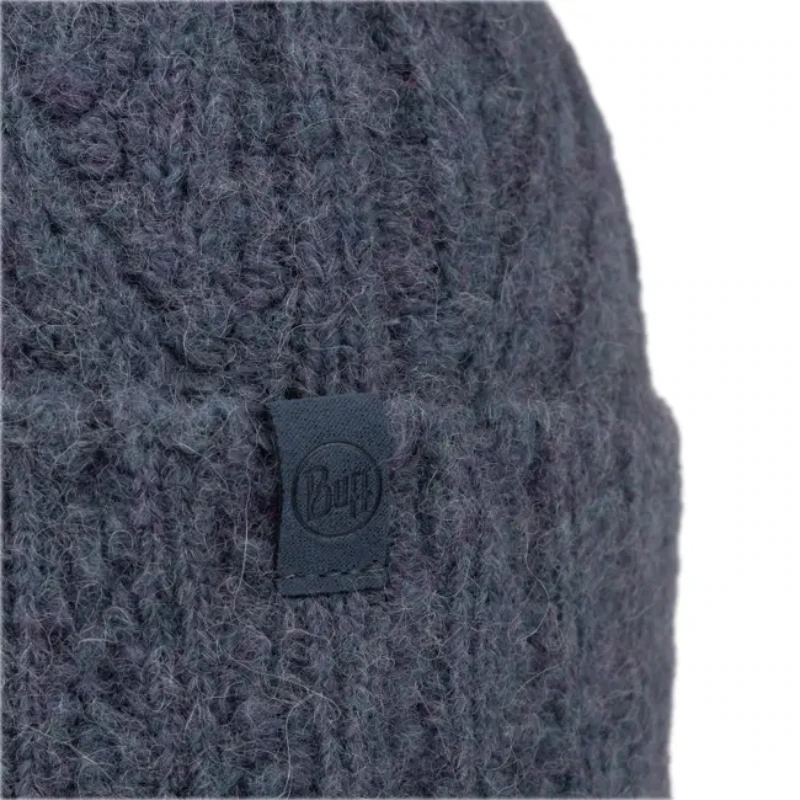 Primer plano del gorro de punto Gorro Buff Knit Beanie Nerla en gris oscuro que muestra su textura acanalada y una pequeña etiqueta de tela redonda en el puño. El fondo blanco acentúa su textura de lana de forma hermosa.
