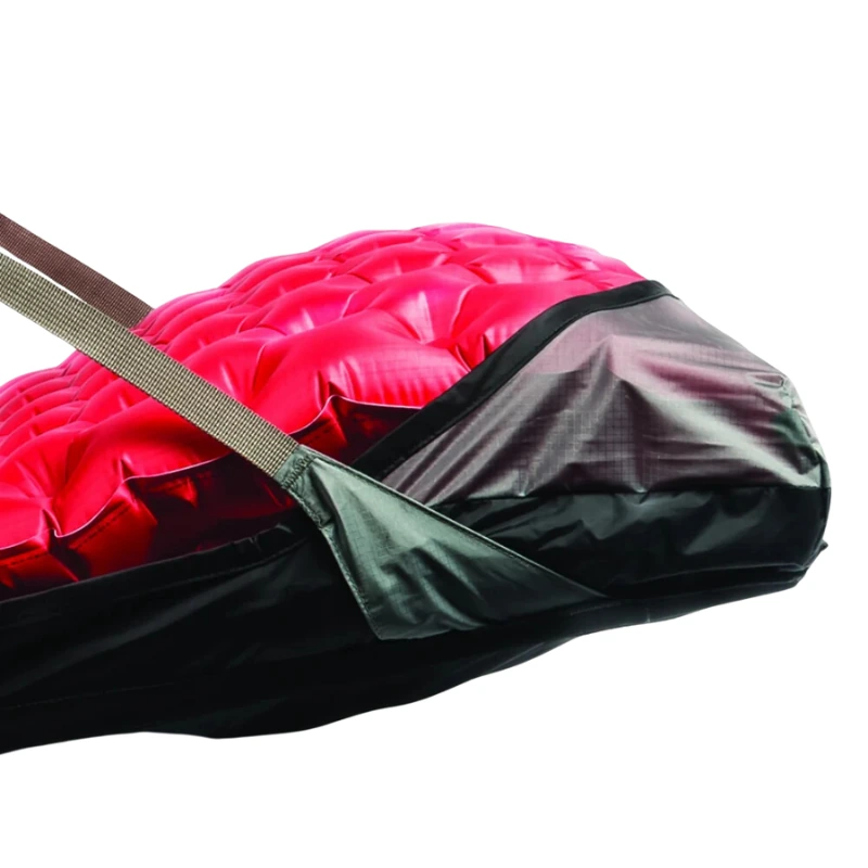 Esta imagen muestra un primer plano de un colchón para senderismo parcialmente desinflado de color negro y rojo, diseñado por expertos para brindar comodidad gracias a su superficie texturizada. Con correas de color beige, combina perfectamente con la silla inflable Sea to Summit Air Chair para disfrutar de una experiencia de campamento ideal.