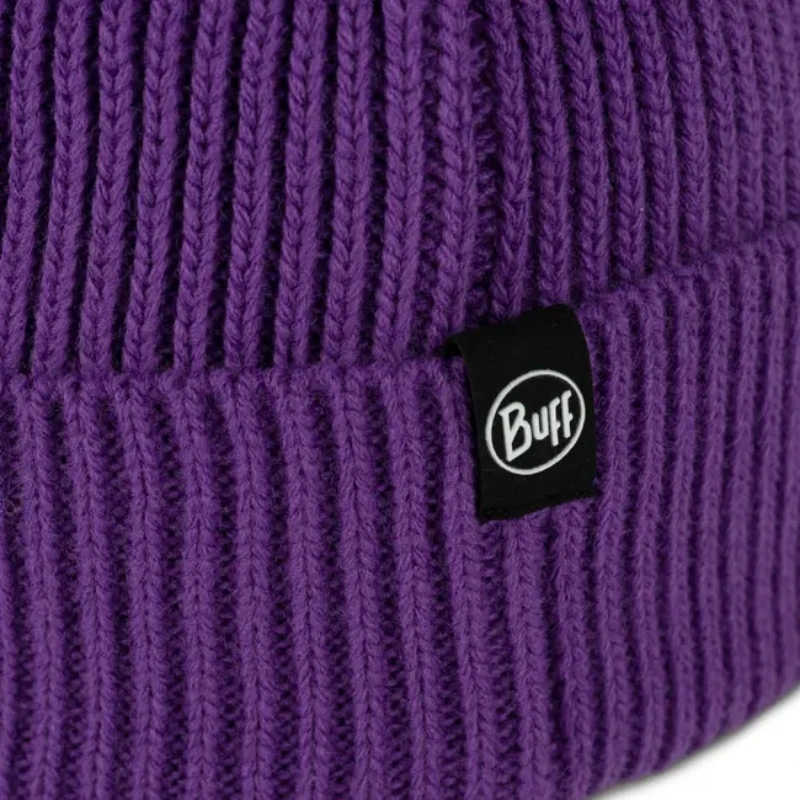 Primer plano de un gorro de punto morado para niños, que muestra una pequeña etiqueta negra con la palabra "Buff" en blanco. El patrón de canalé vertical agrega textura al elegante gorro de punto Buff Niños Rics (copia).