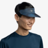 Una persona con cabello corto y oscuro sonríe, vistiendo una visera Visera Buff Go Jaru Black (copia) y una camisa azul oscuro sobre un fondo blanco liso.