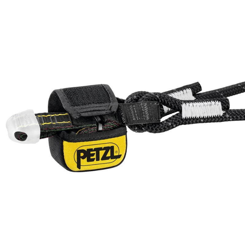 Primer plano del dispositivo de seguridad Petzl, Absorbedor Petzl Absorbica -Y 80, con correa negra/amarilla y funda protectora. Está conectado a una cuerda negra con costuras blancas. Un componente de plástico transparente en un extremo lo hace ideal para uso industrial.