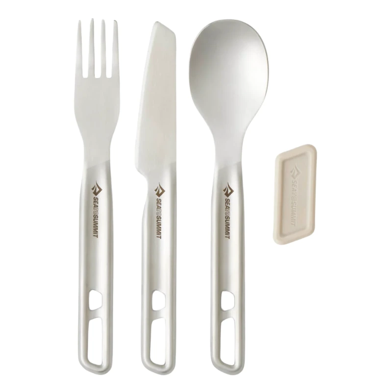 El juego Sea To Summit Detour, que incluye un cuchillo de cocina, un tenedor y una cuchara plateados, cuenta con orificios en el mango para colgarlos. Una pestaña magnética beige realza el diseño, con la marca grabada en cada utensilio.
