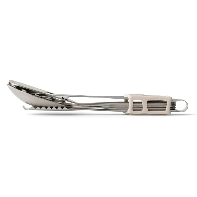Una pinza para alimentos cerrada de acero inoxidable con bordes dentados reposa de lado, mostrando un mecanismo de bloqueo de plástico beige cerca del mango. Esta herramienta, del juego de cocina Sea To Summit Detour de 4 piezas, combina durabilidad con un diseño práctico.