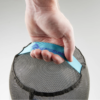Una mano sostiene una correa azul claro "Sea to Summit" sujeta a la parte superior de una bolsa cilíndrica de malla negra, ideal para guardar el Set de Bolsas Secas Ligeras Sea To Summit. La bolsa está parcialmente abierta o expandible.