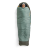 Una persona se acurruca al aire libre en un saco de dormir verde estilo momia, que evoca la calidez acogedora del Saco de Dormir Pluma Sea to Summit Ascent para mujer. Lleva un gorro, y la vibrante cremallera naranja añade un toque de color al fondo blanco.