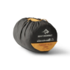 Un saco de dormir negro y naranja, ideal para la Colchoneta Autoinflable Sea to Summit Pursuit Plus, se enrolla en una bolsa con la etiqueta "Sea to Summit Pursuit Plus+ Extra Long" y el detalle de la válvula. Su material duradero y compacto es perfecto para aventuras al aire libre.