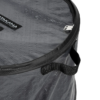 Primer plano del Basurero Plegable Atakama Outdoor Toltén, un bolso cilíndrico negro con una superficie transparente y texturizada, cierre de cremallera, dos asas negras y una etiqueta visible en la parte superior izquierda, perfecto para aventuras al aire libre.