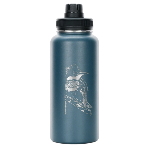 La botella térmica Atakama Outdoor 710ml (copia) en color azul acero luce una tapa negra, una ilustración de un martín pescador blanco y la marca Takeya impresa verticalmente al lado del ave.
