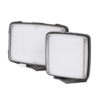 Dos luces LED rectangulares con marcos negros, una más grande que la otra, están colocadas una junto a la otra. Tienen frentes esmerilados y se colocan sobre pequeños soportes, sobre un fondo blanco.