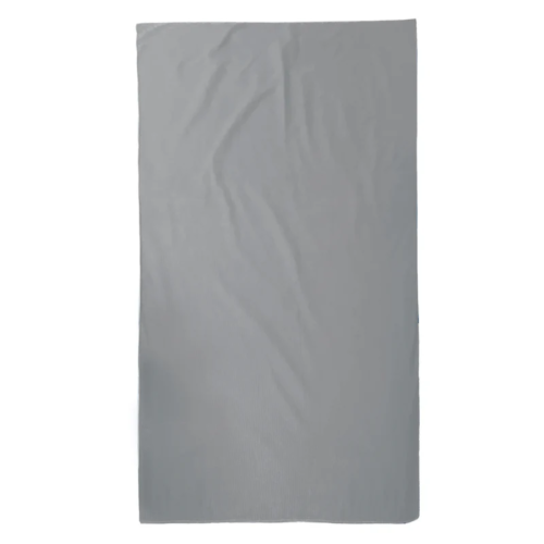Una sábana rectangular gris con ligeras arrugas, colocada plana sobre un fondo blanco, evoca las serenas extensiones de Atakama: es la Toalla Microfibra Atakama Outdoor Maullín.