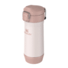 El Despolvillador Stanley Yerbera Mate Stay Fresh 500g, una taza de viaje rosa y blanca con tapa segura y pestillo para mate fresco, se encuentra en posición vertical sobre un fondo blanco.